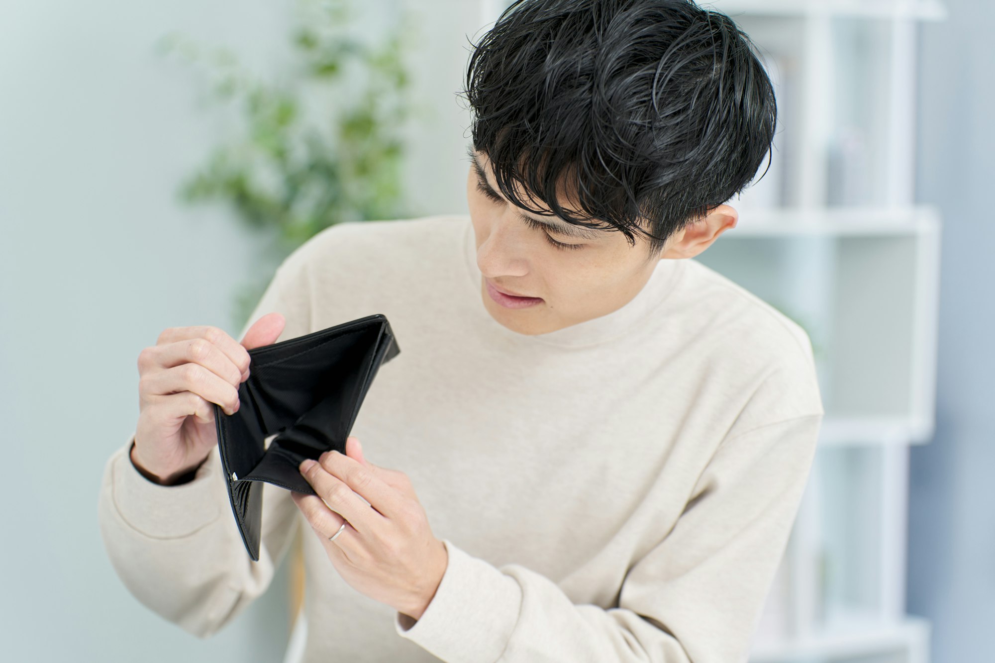 A man holding a wallet with no money in it