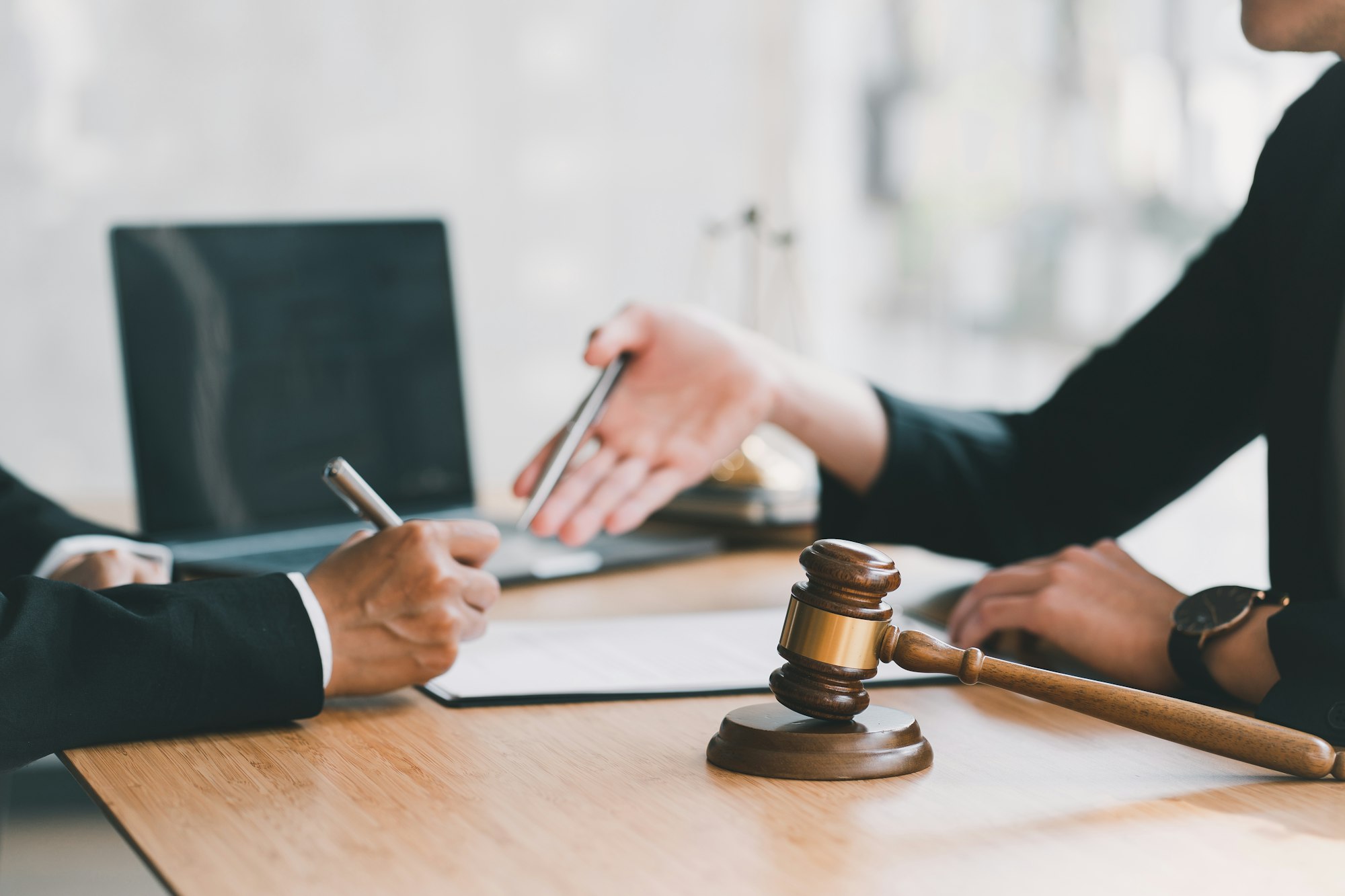 Lawyer working with client discussing contract papers with brass scale about legal legislation i