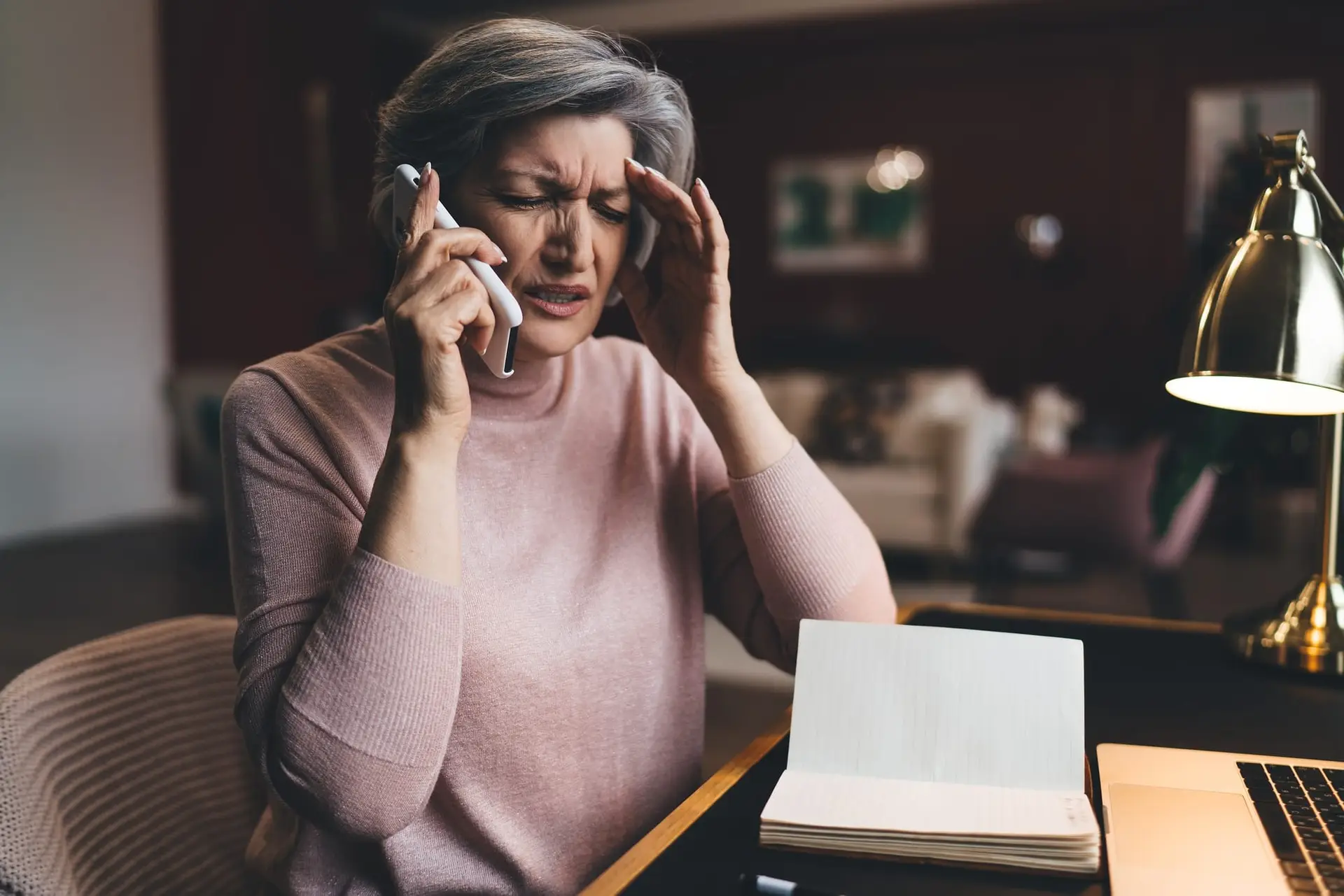 Tired senior woman speaking on smartphone